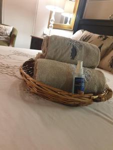 a basket with towels and a bottle of soap on a bed at Kruger Allo B&B in Komatipoort +60 photos