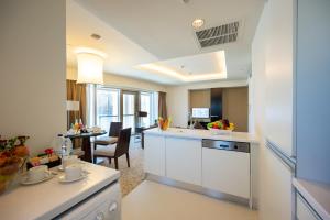 a kitchen with white cabinets and a dining room at Address Dubai Mall Residence - Studio and 1 Bedroom apartments by The S Holiday Homes in Dubai