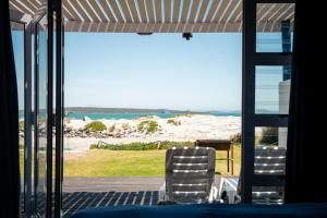 uma vista para a praia a partir do alpendre de uma casa em Friday Island em Langebaan