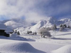a snow covered mountain in front of a house at Studio au pied des pistes- Le Praz de Lys in Taninges