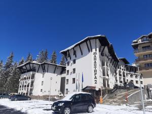 a car parked in front of a large building at Апартамент КАРЛИН in Pamporovo