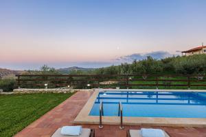 a swimming pool in the backyard of a house at Dimokritos Villas, a homestay experience, By ThinkVilla in Angeliana