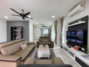uma sala de estar com sofás e uma televisão de ecrã plano em Langkawi Cozy Holiday Home at Taman Indah by Zervin em Kuah