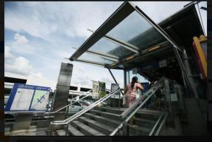 a woman standing on the stairs at a bus stop at Family Room Dmk Don mueang Airport 2 bedrooms in Ban Bang Phang