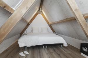 a bedroom with a white bed in a attic at Perfect Stay Holiday, Sea View in Egmond aan Zee