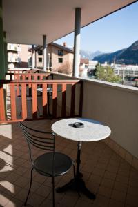a table and a chair on a balcony with a view at Hotel Serenella in Gazzaniga