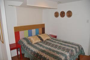 a bedroom with a bed with a colorful comforter at Date & Dine Resort in Antipolo