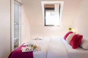 a white bedroom with a bed with a tray of food on it at Rooms 88 in Zagreb