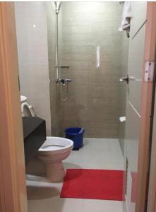La salle de bains est pourvue d'une douche, de toilettes et d'un tapis rouge. dans l'établissement Favila Condotel Unit-150 Newport Boulevard near Airport Terminal 3 and all other Airport, à Manille
