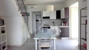 cocina con mesa blanca y armarios blancos en Villa en Nocera Terinese