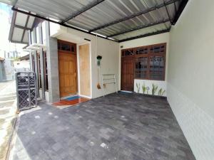a porch of a house with awning and doors at Abadi Homestay in Yogyakarta