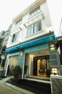 a white building with blue accents on it at AnAn Homestay Huế in Hue