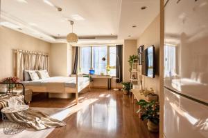 een woonkamer met een bed en een groot raam bij Tianjin G'apartment - Five Great Avenues in Tianjin