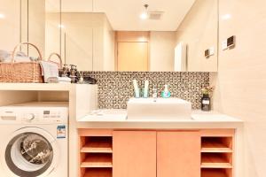a bathroom with a sink and a washing machine at Tianjin G'apartment - Five Great Avenues in Tianjin