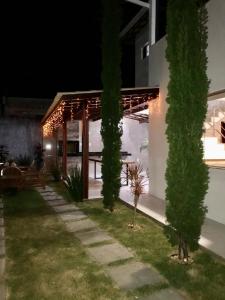 un patio trasero por la noche con una mesa y árboles en Casa Temporada Praia, en Porto Seguro