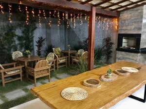 un patio con mesas y sillas y una chimenea en Casa Temporada Praia, en Porto Seguro