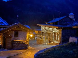a stone house at night with a lighthouse in the background at chalet la grange in Tignes