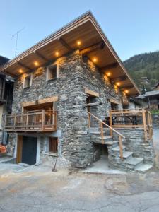 a stone building with a porch and a balcony at chalet la grange in Tignes