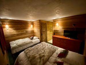 a hotel room with two beds and a television at chalet la grange in Tignes
