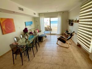 Una sala de estar con una mesa y sillas y un sofá. en Royal Beach House Vista Mar, en La Mata