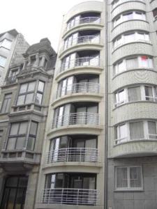 un edificio alto con balcones a un lado. en centraal gelegen app met lateraal zeezicht, en Ostende