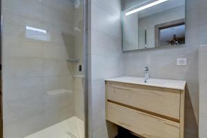 a bathroom with a shower and a sink and a mirror at Lapia 1 in Morzine +9 photos