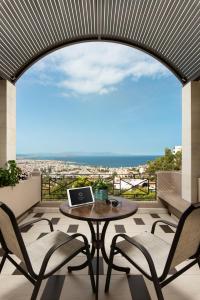 a balcony with a table and chairs with a laptop on it at Royal Sun in Chania