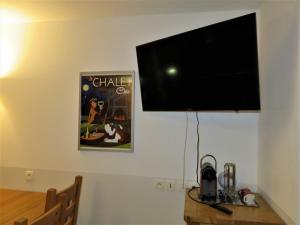 a flat screen tv hanging on a wall at Pensée Des Alpes 2 Etoiles Ski and Spa in Brides-les-Bains