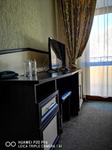a desk with a computer on top of it with a window at Ribkata Family Hotel in Smolyan