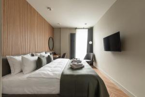a bedroom with a bed with a television on the wall at Potocki Boutique Hotel in Khmelnytskyi