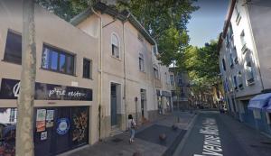 a little girl walking down a street next to a building at Le Refuge Cérétan, grand et bel appartement mansardé en plein centre in Céret