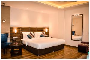 a bedroom with a large bed and a mirror at THE DOWNTOWN in Kānpur