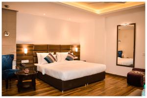 a bedroom with a large bed and a mirror at THE DOWNTOWN in Kānpur