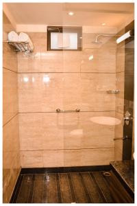 a bathroom with a shower with a glass door at THE DOWNTOWN in Kānpur