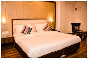 a bedroom with a large bed with white sheets and pillows at THE DOWNTOWN in Kānpur