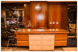 a wooden counter with a clock and chairs in a store at THE DOWNTOWN in Kānpur