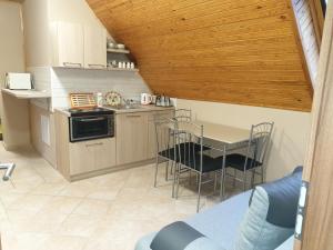 Una cocina y un comedor con mesa y sillas. en Ilda Apartments, en Harkány