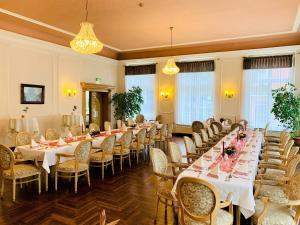 uma sala de banquetes com mesas longas e cadeiras em Parkhotel Pretzsch em Bad Schmiedeberg