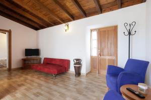 ein Wohnzimmer mit blauen Stühlen und einer roten Couch in der Unterkunft Las Casas del Bisa in Garachico