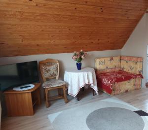 1 dormitorio con mesa, cama y TV en Ilda Apartments, en Harkány