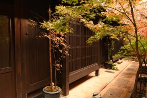 une clôture dans un jardin avec deux arbres dans l'établissement Yado Kiramachi, à Kyoto