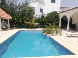 a swimming pool in front of a house at Villa Roka - Toubab Dialaw in Toubab Dialaw