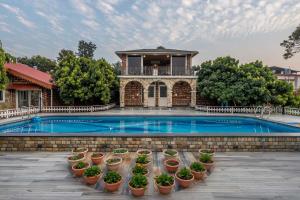 a house with a swimming pool and some potted plants at StayVista at Dudly Manor with Swimming Pool in Dehradun