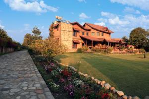 una gran casa de ladrillo con un jardín delante de ella en StayVista at Dudley Manor with Swimming Pool en Dehradun