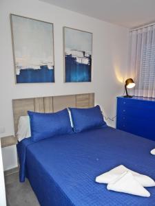 ein Schlafzimmer mit einem blauen Bett mit blauen Kissen in der Unterkunft MAR JÓNICA - Las marinas DENIA in Denia