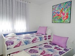 ein Schlafzimmer mit einem Bett mit einer lila und weißen Bettdecke in der Unterkunft MAR JÓNICA - Las marinas DENIA in Denia
