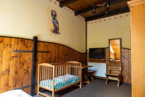 Pokój z łóżeczkiem dziecięcym, lustrem i telewizorem w obiekcie Zajazd Przystocze - Bałtowski Kompleks Turystyczny w Bałtowie