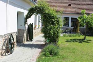 um arco com hera ao lado de uma casa em Axtburg Apartments em Bérbaltavár