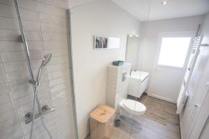 een witte badkamer met douche en toilet bij Salicorne Villa rénovée à l'orée de la zone naturelle in Groffliers +11 foto's