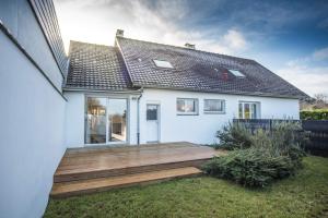 een huis met een houten terras in de tuin bij Salicorne Villa rénovée à l'orée de la zone naturelle in Groffliers